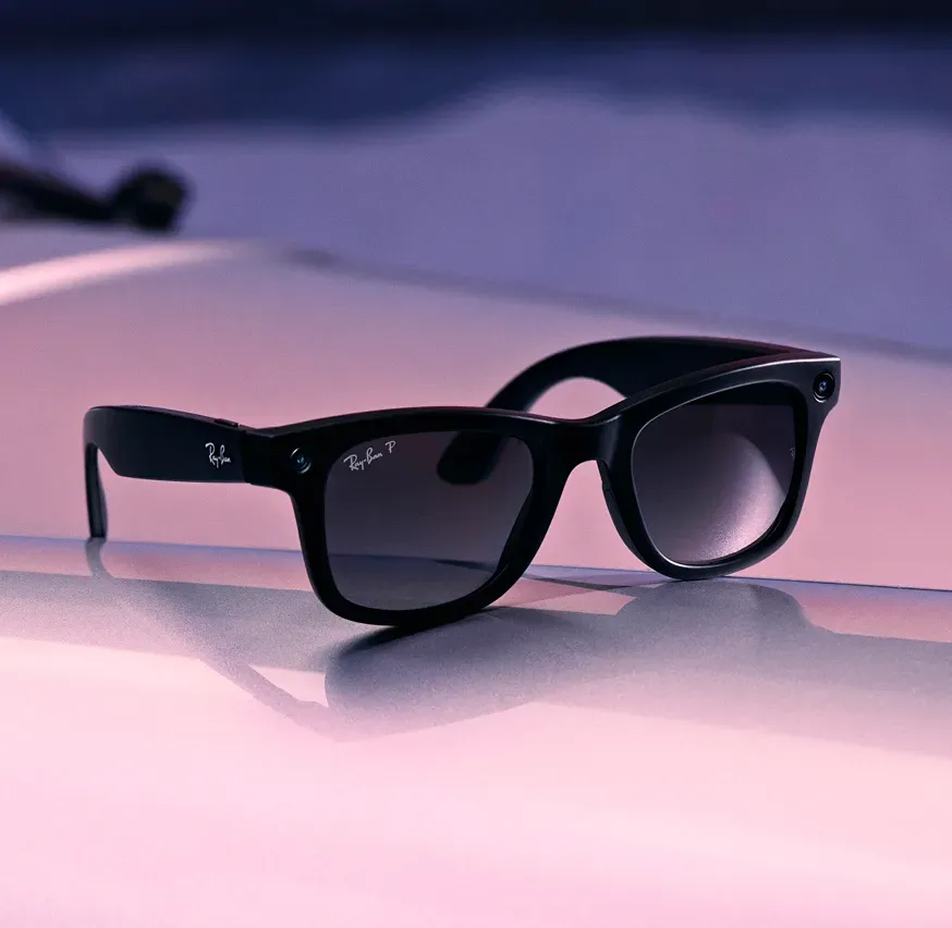 Meta Ray-Ban smart glasses photographed against purple and pink light