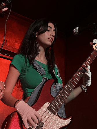 Neta playing bass guitar at a live performance